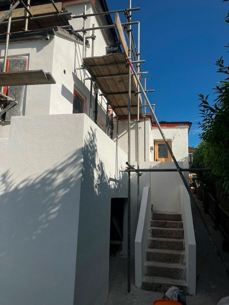 White rendered house extension with scaffolding in place