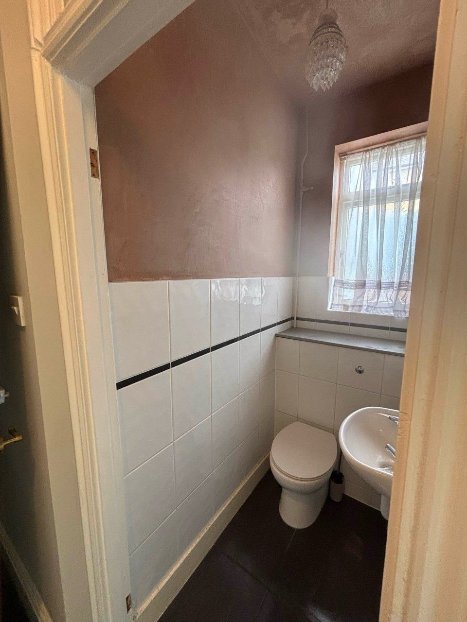 Plastered bathroom wall finished above new tiling