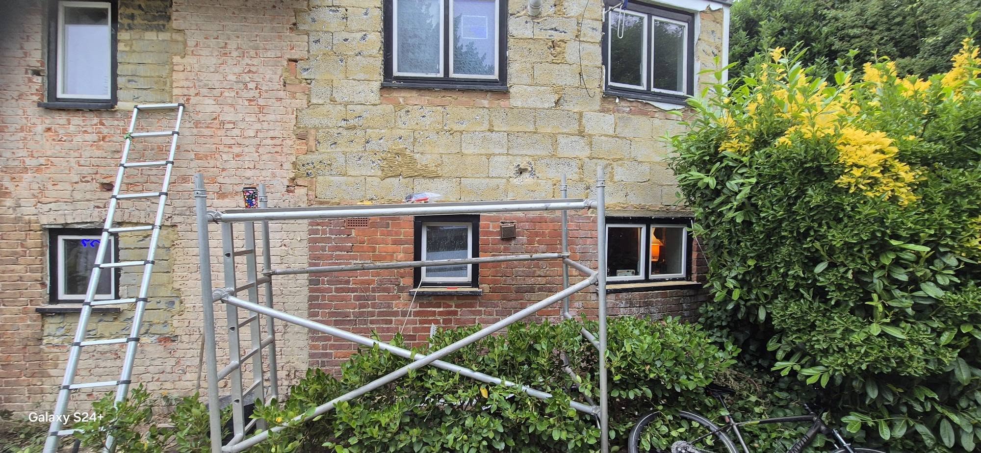 Side elevation in bare brick with scaffolding before rendering