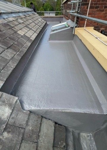 Completed grey GRP fibreglass flat roof with a clean upstand and trim
