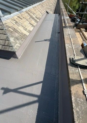 Close detail of a fibreglass flat roof upstand and edge trim against brickwork
