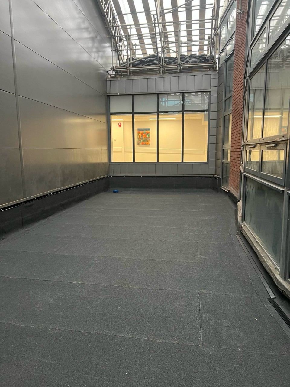 Finished flat roof terrace area alongside a glazed building elevation