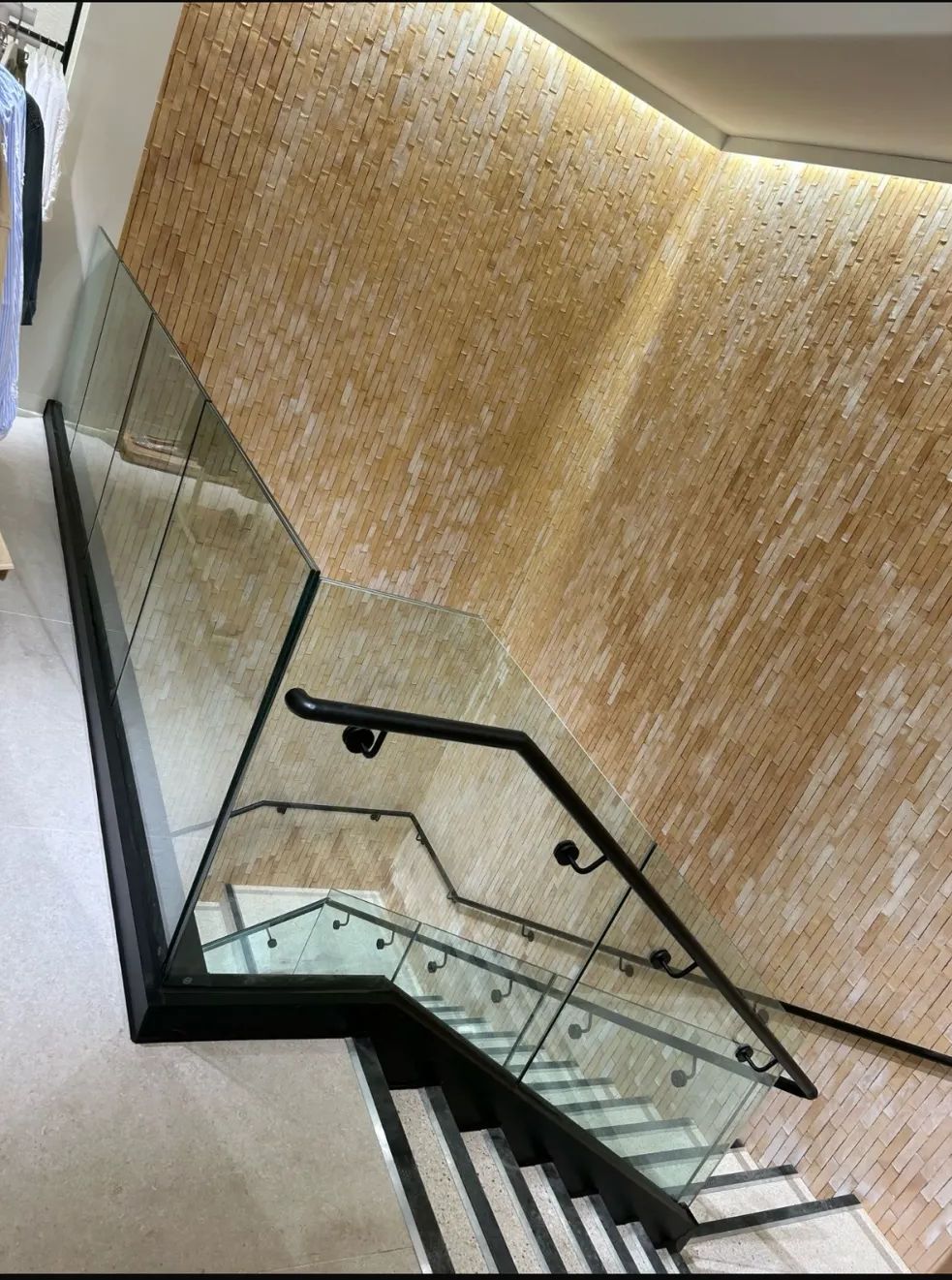 Glass balustrade staircase against stone