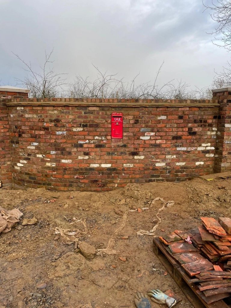 Rustic reclaimed red brick garden wall with a post box built in