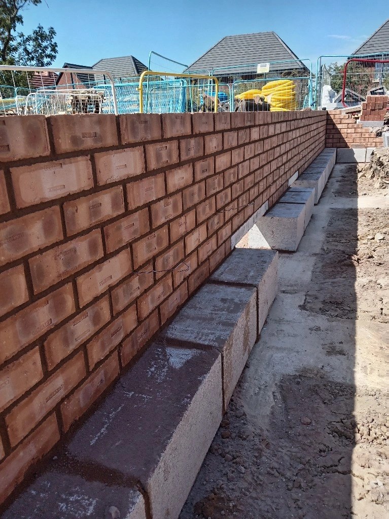 A long red brick garden wall