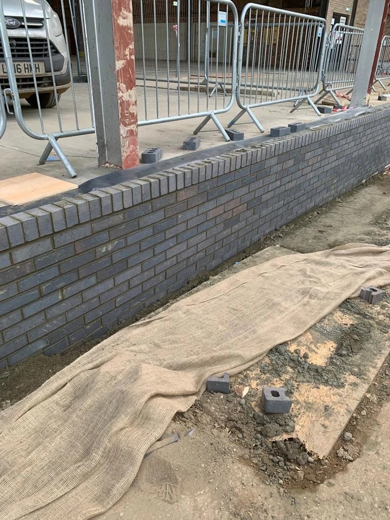 A dark engineering-brick boundary wall
