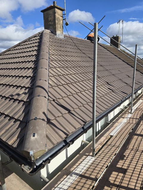 Hipped tile roof with new black guttering and scaffold