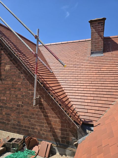 Red clay tile roof with a chimney and new lead flashing