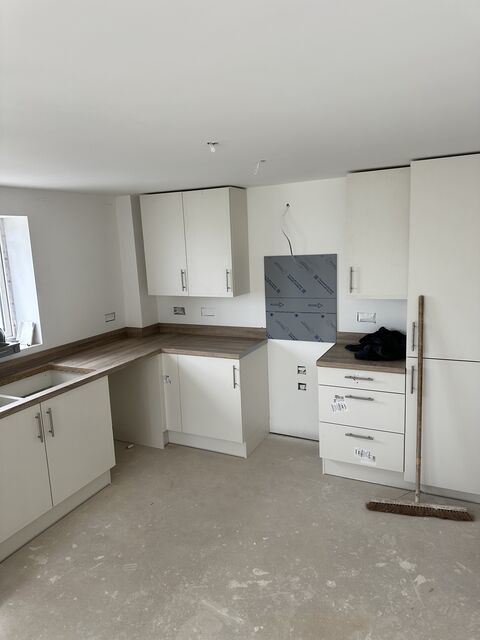 Cream kitchen with a wood-effect worktop and window