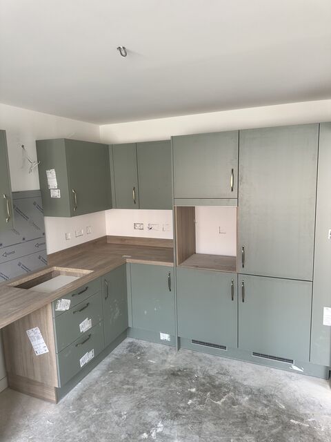 Two-tone sage green and cream kitchen with a wood worktop