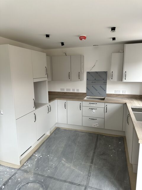 Cream kitchen with wood-effect worktops and a tall integrated unit run