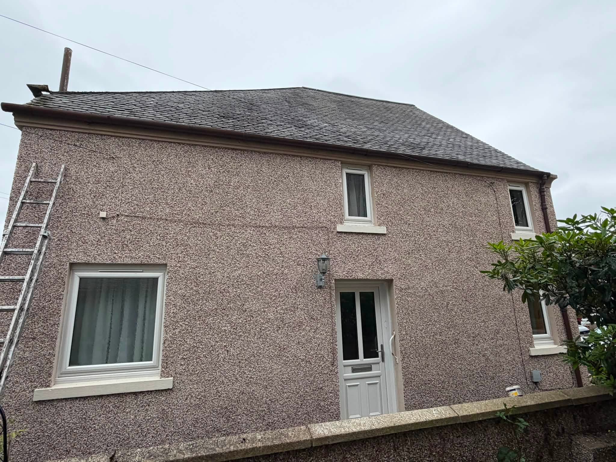 House exterior with ladder set up for roof work