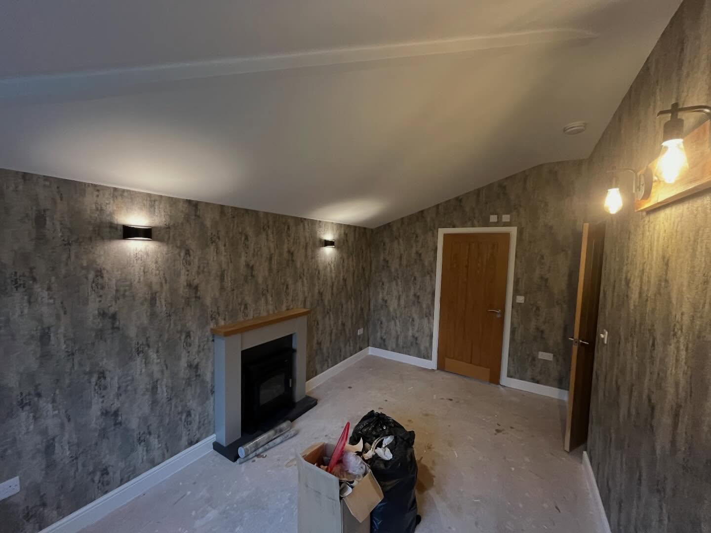 RWT Decorators lounge with textured feature wallpaper, fireplace and oak door