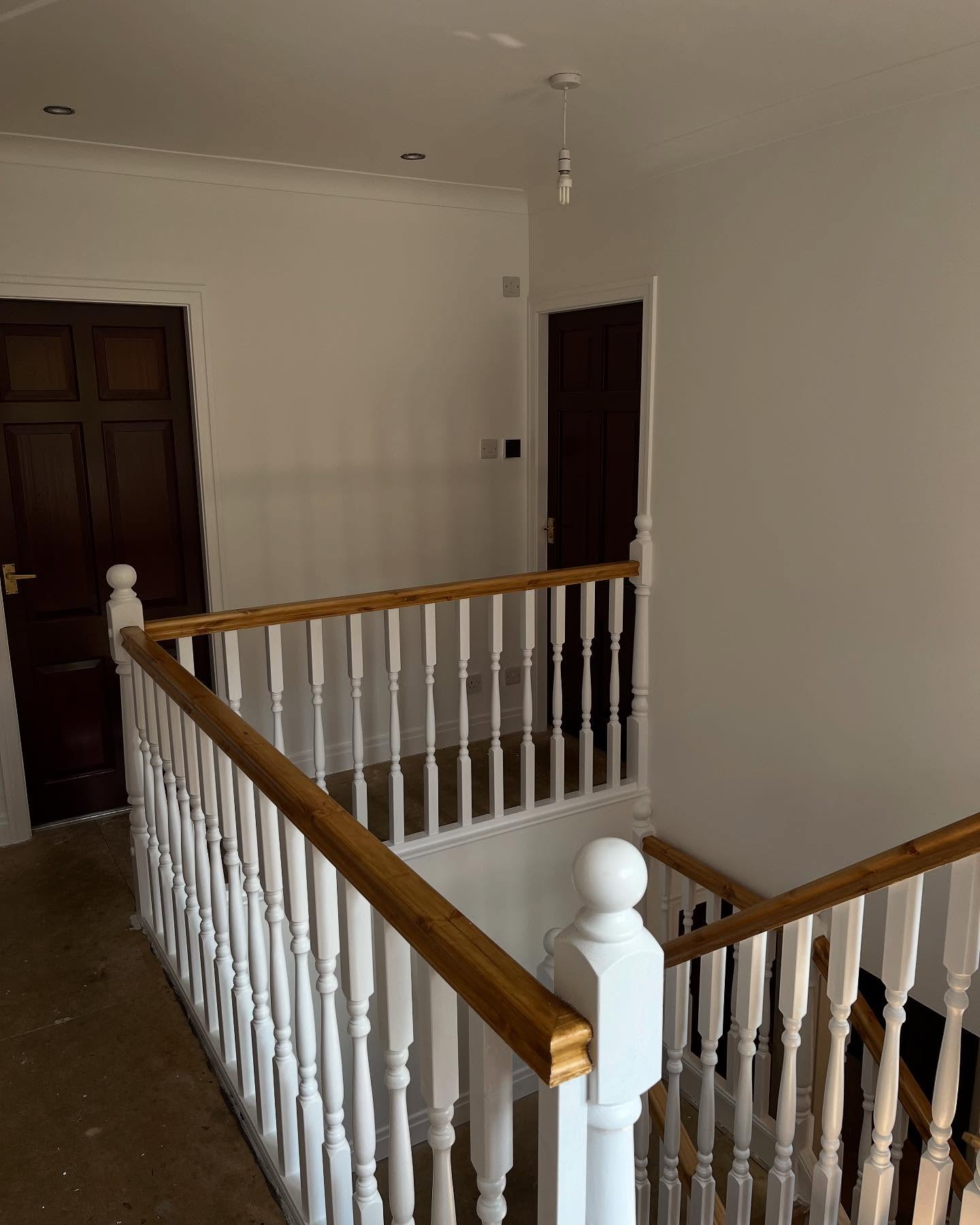 RWT Decorators white-painted staircase spindles with a stained oak handrail
