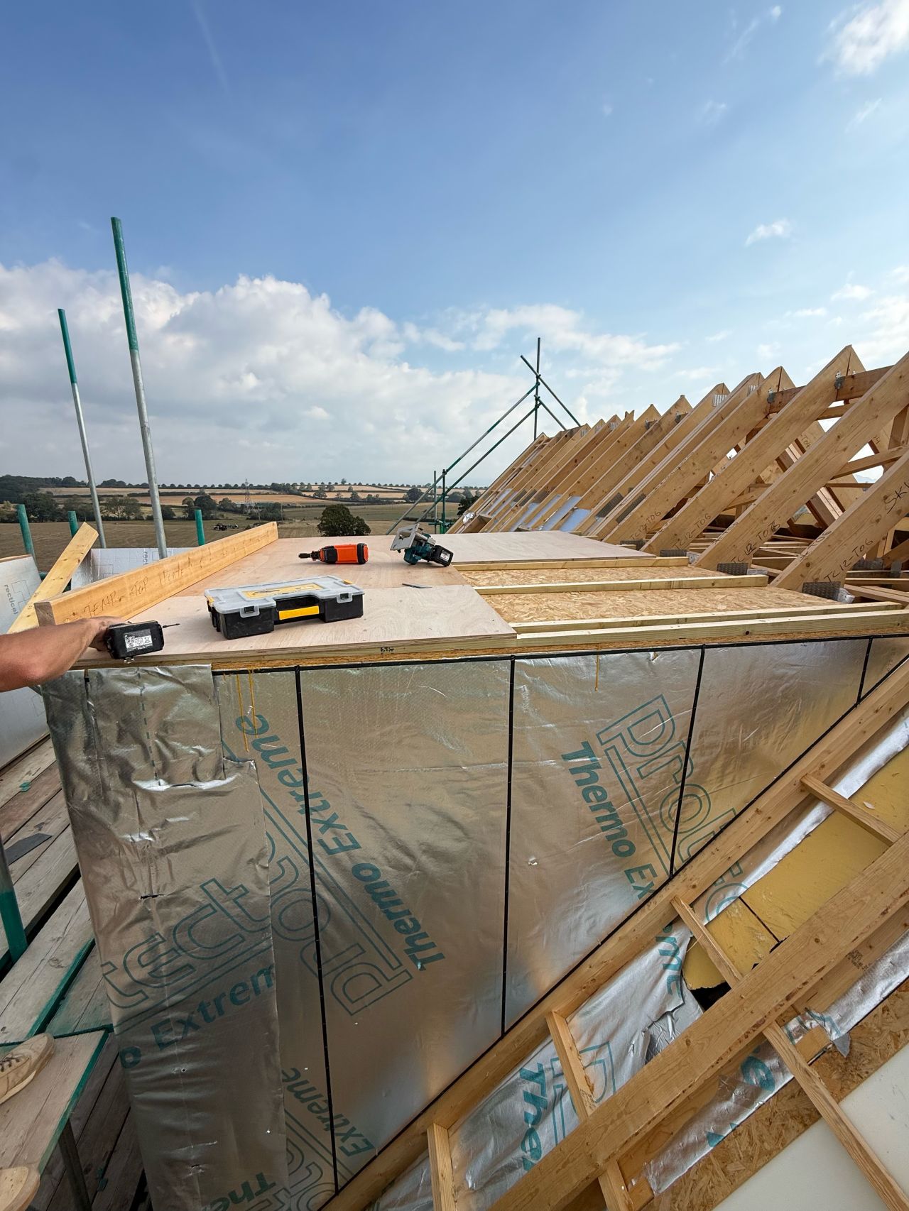 Roof trusses going up against a blue sky