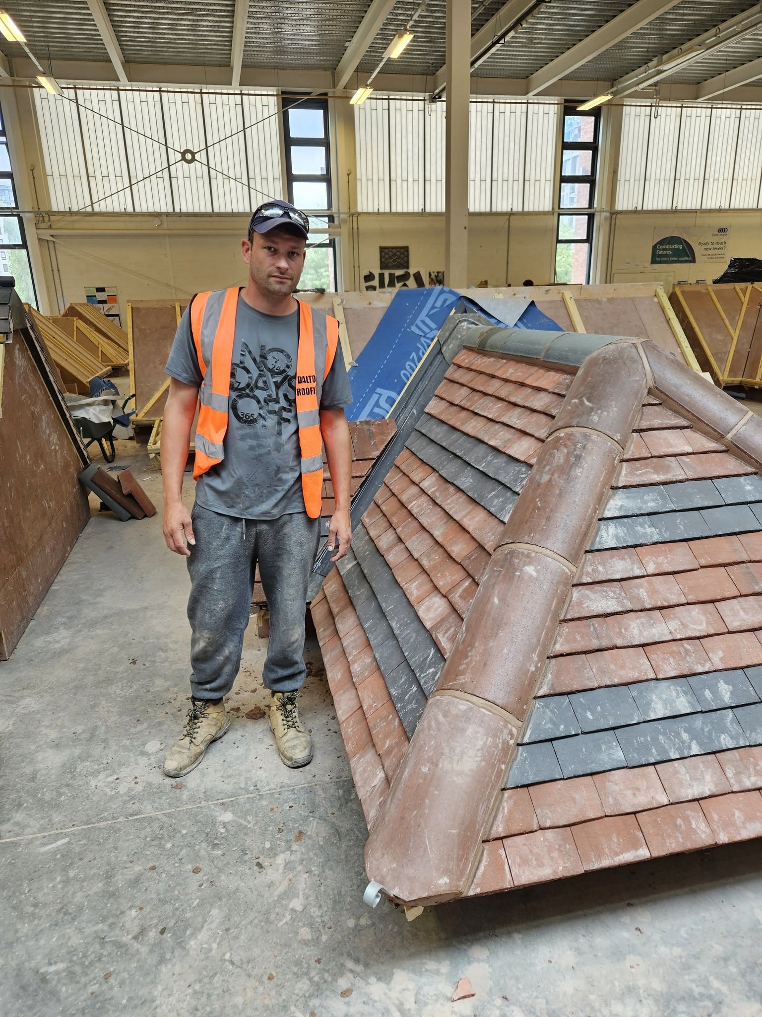 Ashley Peet, owner of Trusty Roofers, beside a tiled training roof