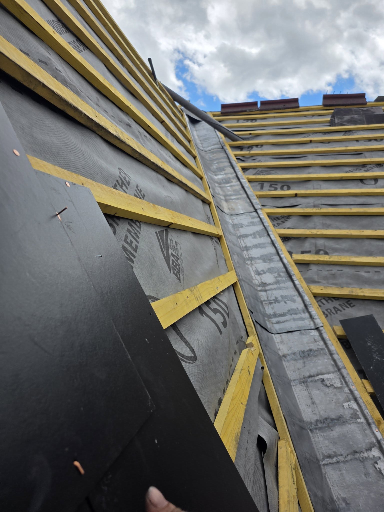 Full re-roof in progress with new timber battens and grey breathable membrane